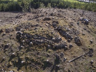Post-excavation aerial photograph of Trench 1 by Ed Martin, looking south east over the W side of the dun (Trench 1); image shows the curvilinear outer wall face alignment, Comar Wood Dun, Cannich, Strathglass