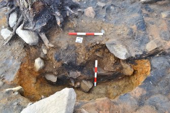 Mid-excavation image of posthole 151 after removal of packing stones and half-sectioning, Comar Wood Dun, Cannich, Strathglass