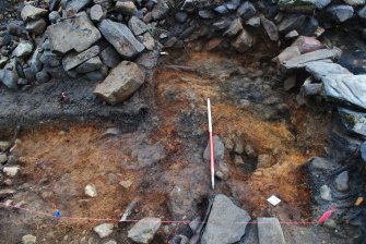 Mid-excavation image of Trench 1, south extension, showing cobble fill at base of deposit in top right and posthole 186 (centre right), Comar Wood Dun, Cannich, Strathglass