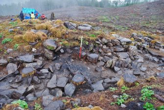 Post-excavation image of north facing section of Trench 1, showing possible collapsed stonework in the dun entrance, areas of burning and outer wall face structure, Comar Wood Dun, Cannich, Strathglass