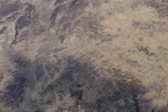 Oblique aerial view of the hut circles and field system at Drumturn Burn in Glen Shee, looking N.