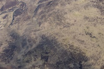 Oblique aerial view of the hut circles and field system at Drumturn Burn in Glen Shee, looking N.