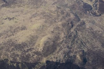 Oblique aerial view of the hut circles and field system at Drumturn Burn in Glen Shee, looking SSW.