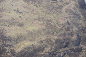 Oblique aerial view of the hut circles and field system at Drumturn Burn in Glen Shee, looking S.