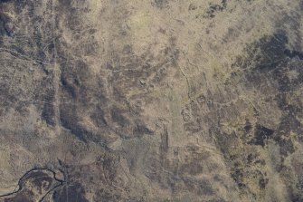 Oblique aerial view of the hut circles and field system at Drumturn Burn in Glen Shee, looking ENE.