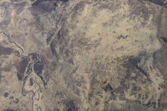 Oblique aerial view of the hut circles and field system at Drumturn Burn in Glen Shee, looking NNE.