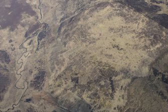 Oblique aerial view of the hut circles and field system at Drumturn Burn in Glen Shee, looking N.