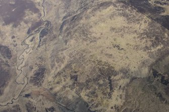 Oblique aerial view of the hut circles and field system at Drumturn Burn in Glen Shee, looking N.