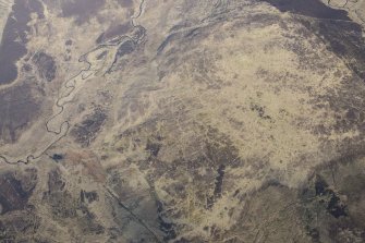 Oblique aerial view of the hut circles and field system at Drumturn Burn in Glen Shee, looking NNW.