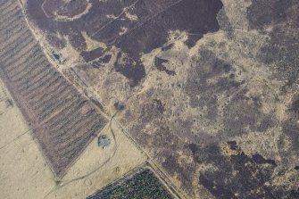 Oblique aerial view of the Grey Cairn, hut circles and cairnfield at Balnabroich, Strathardle, looking N.