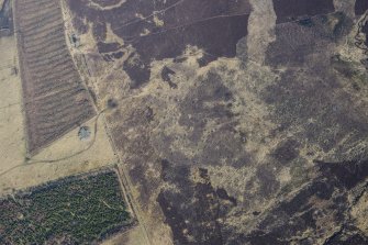 Oblique aerial view of the Grey Cairn, hut circles and cairnfield at Balnabroich, Strathardle, looking NNW.