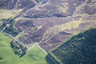 Oblique aerial view of a ring cairn and Pitcarmick buildings at Lair in Glen Shee, looking SW.