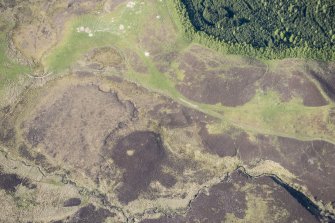 Oblique aerial view of Pitcarmick buildings, hut circles and ring cairn at Lair in Glen Shee, looking NNE.