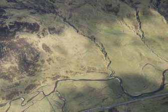 Oblique aerial view of a farmstead, head dyke and rig in Gleann Beag, looking SE.