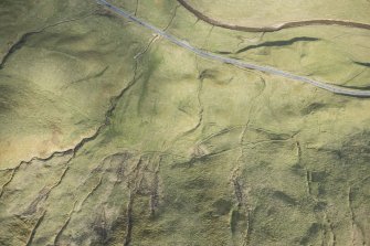 Oblique aerial view of a farmstead, mill and other buildings in Gleann Beag, looking ESE.