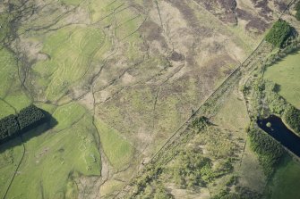 Oblique aerial view of the Pitcarmick building, cairnfield, townships and field system at Gleann Fearnach on the slopes of Creag Dubh Leitir, looking NNW.