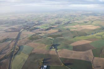 General oblique aerial view along the M90 with Milnathort in the distance and Blairnathort farmstead in the foreground, looking SSE.