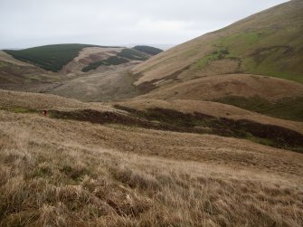 A view looking N centred on the Roman watch tower at the pass of Ewes Doors, with the valley of the Wrangway Burn in the background. A tripod marks the centre of the site.