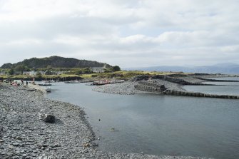 Harbour and shingle beach with gabion slate filled piers, view from east