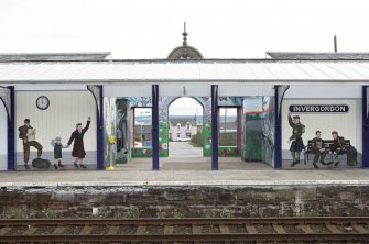 Entrance and adjacent murals, view from across tracks to north