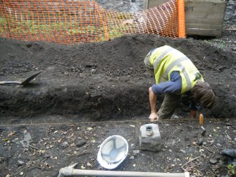 Working view, excavating west end of trench, photograph from an archaeological excavation at Acheson House, Canongate, Edinburgh