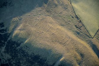 Oblique aerial view of the township, field system, hut circles, ring cairns and cairnfield on Strone Hill, looking SE.