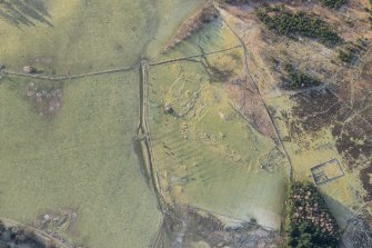 Oblique aerial view of the farmstead and standing stone at Clach More, looking SW.