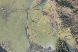 Oblique aerial view of the farmstead and standing stone at Clach More, looking SSW.