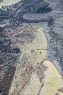 Oblique aerial view of the hut circle, enclosure and cairnfield at Loch Charles, looking SSW.