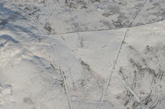 Oblique aerial view of the building, clearance cairns and military road at Corrymuckloch, looking N.