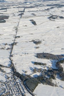 Oblique aerial view of the Roman fort and road at Ardoch, looking NNE.