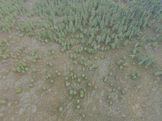 Oblique aerial view of hut circles F, G and H looking NE, with hollow ways in the foreground.