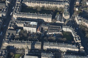 Oblique aerial view of the construction of student flats on the site of the former printing works and John Sinclair House, looking N.