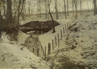 General view of snow-covered grounds showing foot bridge, The Peel, Busby
