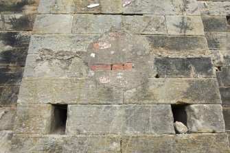 West elevation. Detail of blocked pipe opening on bob wall buttress. Socket holes below.