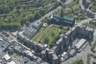 Oblique aerial view of Cathedral of St Mungo Burial Ground, Glasgow Cathedral and the Royal Infirmary, looking SE.