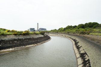General view of water channel from east. This channel cools the process water prior to its entering into the River Forth (behind the camera). Power station visible in background