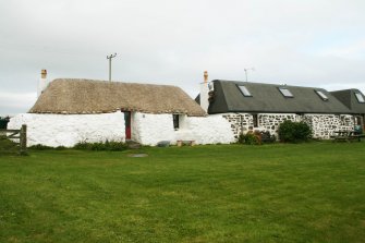 General view of 2 restored 19th century cottages,one thatched roof and one 'traditional' black felt roof; Tiree, Kilmoluaig.