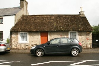 View of late 18th century cottage showing reed thatched roof and concrete ridge, some mossy growth on thatch; Hawthorne Cottage, Longforgan.