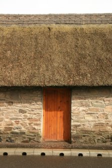 Detail of doorway, thatched roof and ridge on east cottage;  Quoins Cottage, Longforgan Main Street.