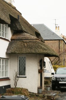 Side view to show thatching over doorway; Rose Cottage, Town Yetholm.