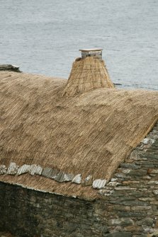 Detail of roof and netted straw thatched chimney stack; Southvoe croft house museum, Shetland.
