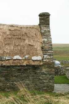 Detail of roof and chimney stack with stone weights;Southvoe croft house museum, Shetland.
