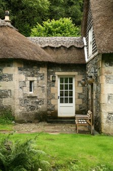 View of thatched roof and decorative ridge above side door of cottage; Craigengillan, Glessel.