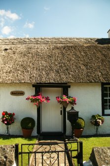 View of thatched roof and ridge above doorway; Rose Cottage, Collessie.