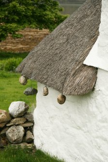 View of roof corner showing stone weights;  2 Luib, Skye.