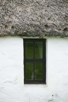View of thatching with stone weights above window; Totscore, Skye.