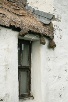 Detail of thatching with lead skew and stone weights above window; Totscore, Skye.