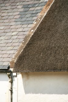 Detail of thatch at skew beside slated roof at number 29; 30 High Street, Avoch.