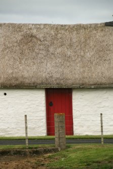 View of thatched roof over doorway showing stone and concrete slabs; Laidhay Croft Museum.